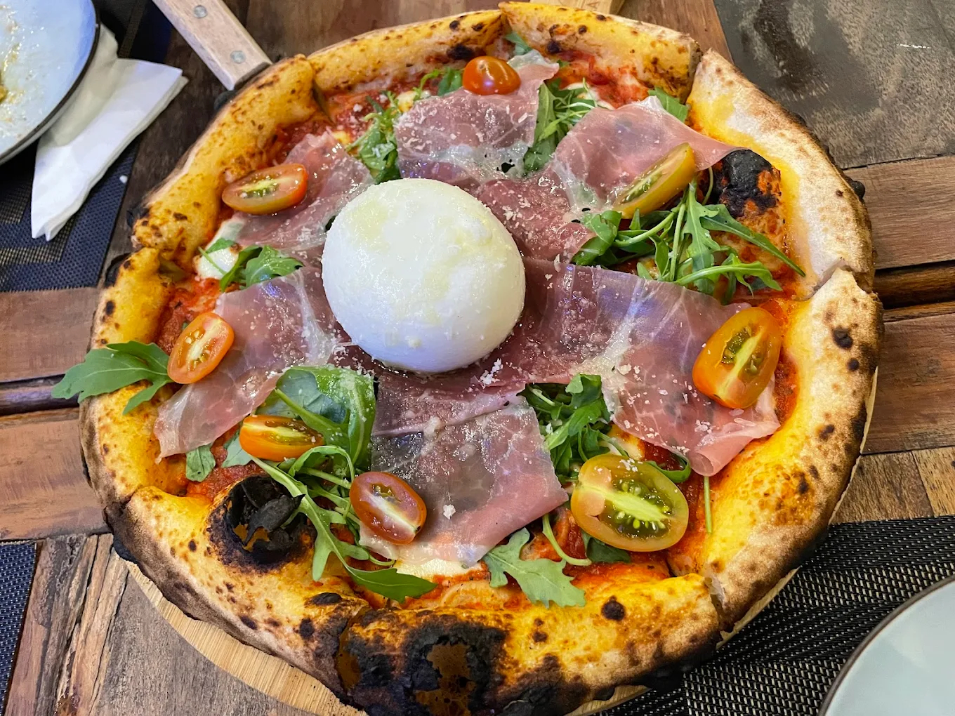 The pizza is baked to a perfect crisp with a thin base and generous toppings